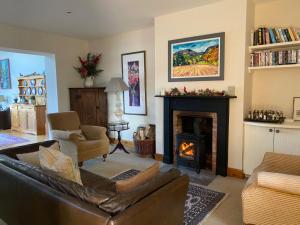 a living room with a couch and a fireplace at Spacious cottage - walk to Crieff in Crieff