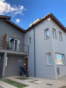 una motocicleta estacionada frente a una casa blanca en Terrazas de la Patagonia en Esquel