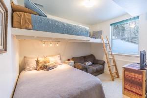 a bedroom with a bunk bed and a couch at River Walk Haven in Ouray