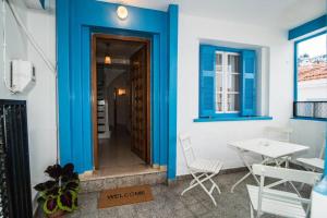 a room with blue walls and a table and chairs at Avli Townhouse in Skopelos Town