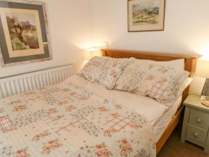 a bedroom with a bed with a quilt on it at Sunny Cottage in Darlington