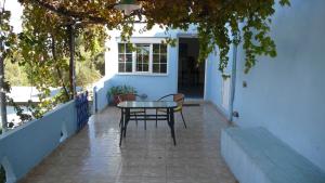 a patio with a table and chairs on a porch at Stefanos Garden in Arménoi