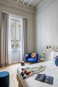 a bedroom with a bed and a chair and a window at Dimora72 Luxury Rooms in Florence