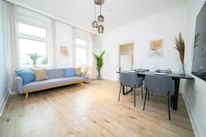 a living room with a blue couch and a table at Favorite Stays - Suite And More - Kitchen in Neuss