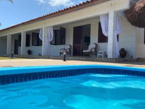 a house with a swimming pool in front of it at Casa Pé na Areia in São José da Coroa Grande