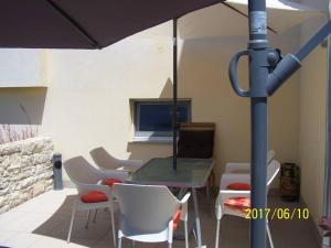 a table and chairs with an umbrella on a patio at Vita Garden Apartment 85 m2 Private Entrance & 100 m2 Terrace in Pula