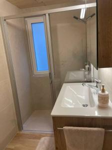 a bathroom with a sink and a shower with a mirror at Apartment Bellavista in Saas-Grund