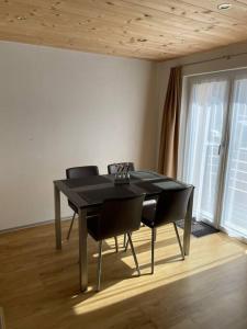 a black table and chairs in a room with a window at Apartment Bellavista in Saas-Grund