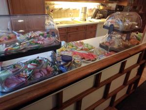 a counter with two trays of different types of food at Gästehaus Luise in Monschau