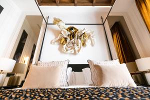 a bedroom with a large bed with white pillows at Hotel Casa Palacio Don Ramón in Seville