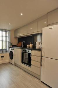 a kitchen with white appliances and a white refrigerator at No. 3 Bligh's Yard in Canterbury