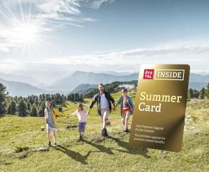 a group of people walking in a field with a sign at MyHome Apartments Umhausen in Umhausen