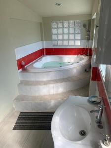 a bathroom with a bath tub and a sink at Hotel y Restaurante Rincón Familiar in La Libertad