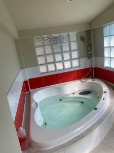 a bath tub in a bathroom with red tiles at Hotel y Restaurante Rincón Familiar in La Libertad