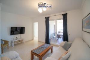 salon z kanapą i stołem w obiekcie Apartamento Cigüeña w mieście Sanlúcar de Barrameda