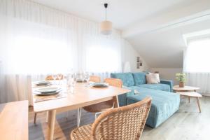 a living room with a table and a blue couch at Löwe Apartments "Blau" Neuhausen am Rheinfall in Neuhausen am Rheinfall