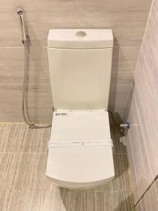 La salle de bains est pourvue d'une douche et de toilettes blanches. dans l'établissement أزار للشقق الفندقية, à Abyār ‘Alī