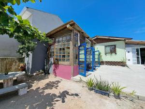 un bâtiment avec des portes colorées sur le côté dans l'établissement Casa Rústica com Churrasqueira e Wi-fi na Praia!, à Matinhos