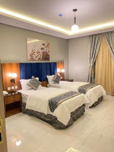 a hotel room with two beds in a bedroom at أزار للشقق الفندقية in Abyār ‘Alī