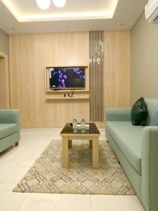 أزار للشقق الفندقية في آبار علي: غرفة معيشة مع أريكة وطاولة قهوة