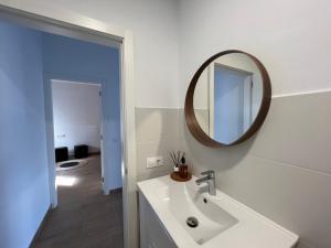 a white bathroom with a sink and a mirror at Callao home in Moya