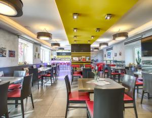 a restaurant with tables and chairs and yellow ceilings at Motel Route66 in Čechy
