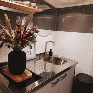 a kitchen with a sink and a vase of flowers at B&B Mañana in Cuijk