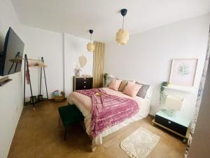 1 dormitorio con 1 cama con colcha rosa en Big House Adeje Deluxe By Deihu Experiences, en Adeje