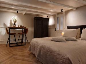 a bedroom with a bed and a table with a bar at Studio Mañana in Cuijk