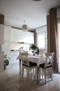 a white kitchen with a white table and chairs at A Casa Tua in Bologna
