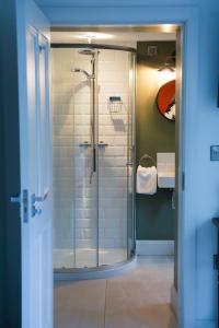 een badkamer met een douche en een glazen deur bij The Old Bushmills Barn in Bushmills