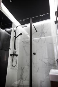 a bathroom with a shower with white marble at APARTAMENT Welurowy in Kielce