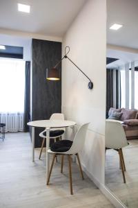 a dining room with a white table and chairs at APARTAMENT Welurowy in Kielce