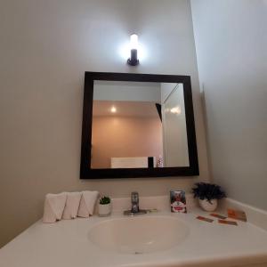 Hotel Cali Blvd. في Guadalupe: حوض الحمام مع مرآة كبيرة فوقه
