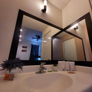 Hotel Cali Blvd. في Guadalupe: حمام مع حوض ومرآة كبيرة