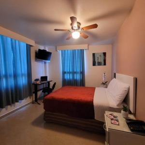 a bedroom with a bed and a ceiling fan at Hotel Cali Blvd. in Guadalupe