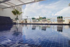 a swimming pool with lounge chairs next to a building at Casa Mexicana Cozumel in Cozumel