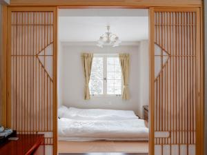 a bedroom with two beds and a window at Hakuba Sun Valley Hotel Annex - Vacation STAY 90355v in Iida