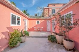 a pink building with potted plants in a courtyard at Art Deco Townhouse in the Heart of Hollywood in Los Angeles