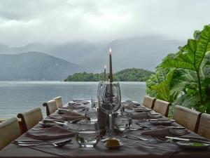 a table that has a glass of wine on it at Puyuhuapi Lodge & Spa in Puerto Puyuhuapi