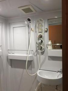 a white bathroom with a shower and a sink at Hakuba Sun Valley Hotel Annex - Vacation STAY 90337v in Iida