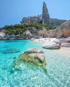 una spiaggia con alcune rocce e acqua blu di Da Giorgio a Lotzorai