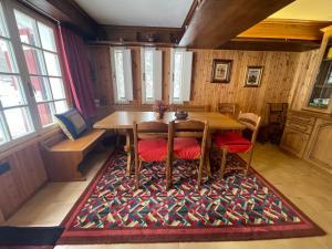 uma sala de jantar com uma mesa e cadeiras num tapete em I Larici - Appartamento per sognare em Alpe Devero