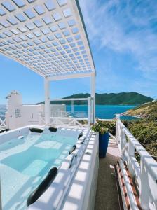 uma banheira de hidromassagem numa varanda com vista para o oceano em Casa Mar da Grécia em Arraial do Cabo