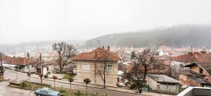 a city with houses and a mountain in the background at Явор in Tryavna