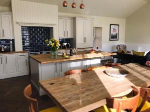 a kitchen with a wooden table and a counter top at Gardeners cottage in Pitlochry