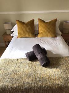 a bed with two pillows and two towels on it at Gardeners cottage in Pitlochry