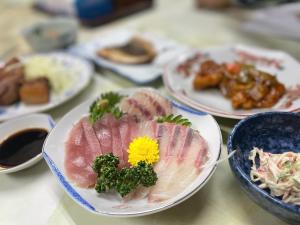 una mesa cubierta con platos de comida en la parte superior en Ryokan Warajisha - Vacation STAY 67784v, en Goto