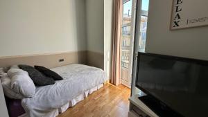 a bedroom with a bed and a flat screen tv at Moderno estudio en Porta Do Sol in Vigo