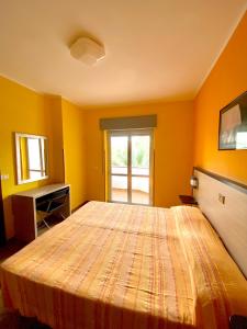 a bedroom with a large bed with orange walls at Residence Hotel Felix in Ricadi